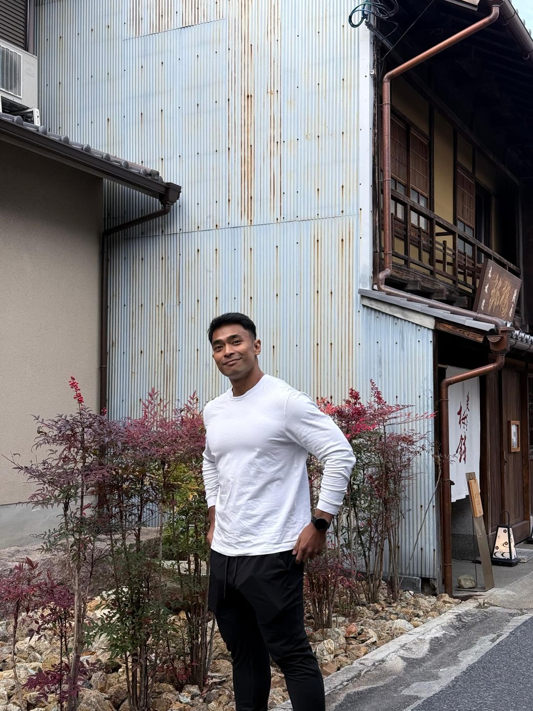 Riz from Built By Riz standing outside in a white long sleeve top